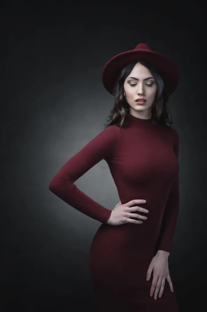Jeune femme posant en robe rouge pour se faire prendre en photo.