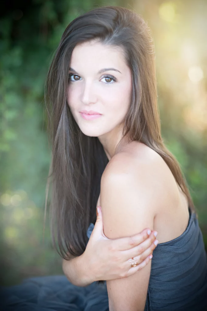Jeune femme de profil avec le visage en face de l'objectif pour une session photo en Dordogne.